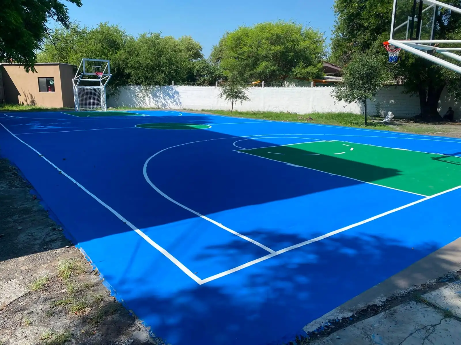 Cancha de básquetbol pintada en azul, con sus líneas