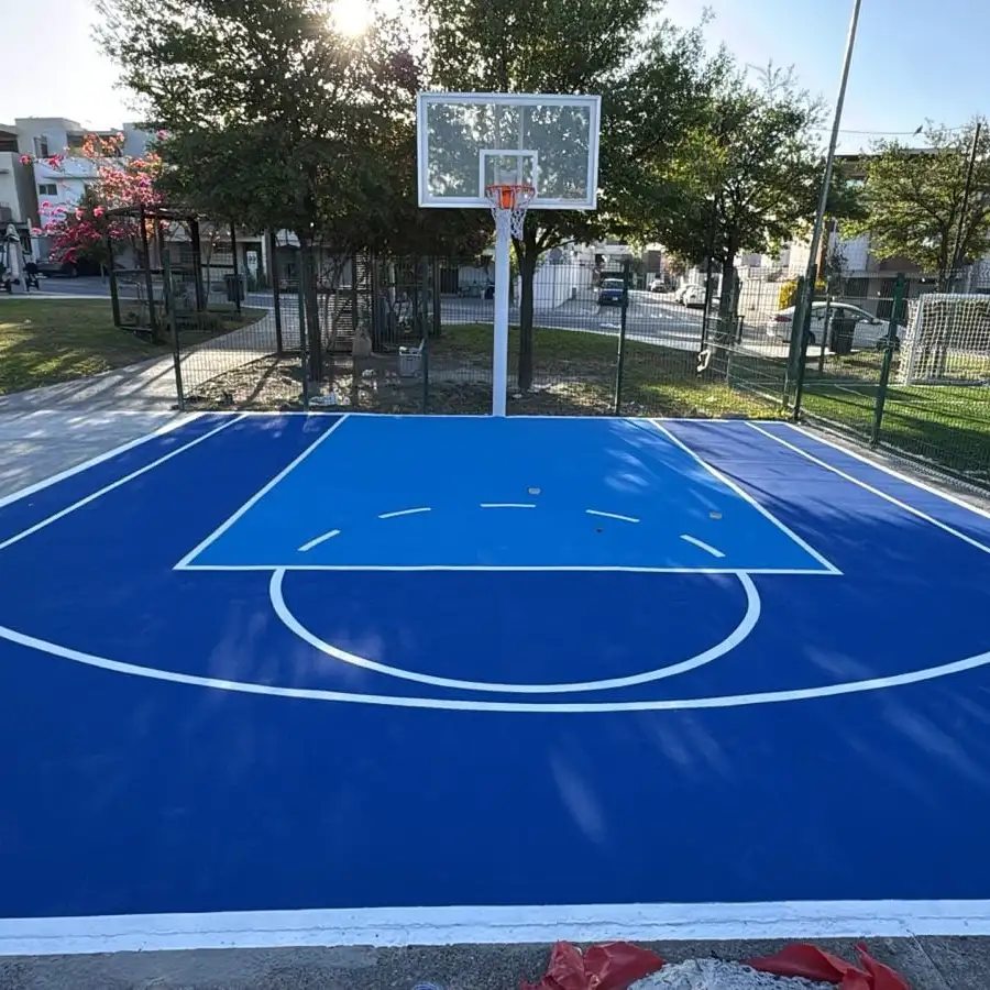 Cancha de básquetbol pintada en azul dentro de un fraccionamiento
